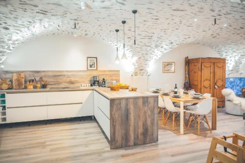 a kitchen and dining room with a table and chairs at Maison de village - Les Voûtes Blanches - Serre Chevalier 1350 in Saint-Chaffrey