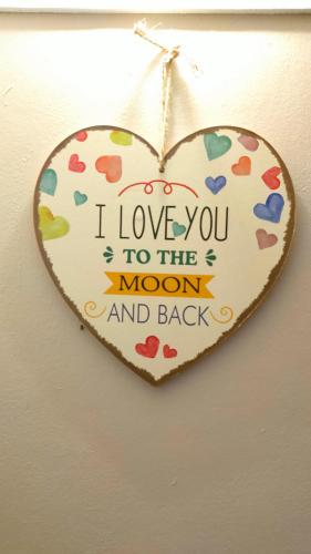 a heart shaped sign that says i love you to the moon and back at Aleesa Roomstay & Hotel in Pasir Puteh