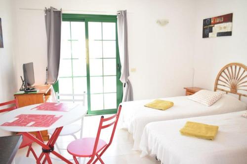 pokój z dwoma łóżkami, stołem i oknem w obiekcie Caleta Paraiso Sea View 137 w mieście Costa de Antigua