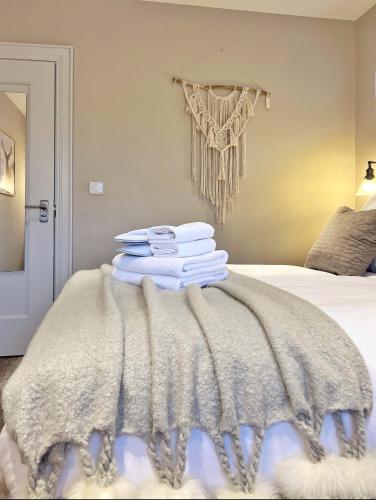 a pile of towels sitting on top of a bed at The Hideaway Retreat in Omagh