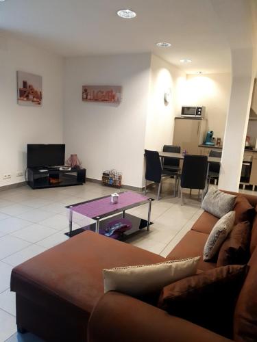 a living room with a couch and a table at Les Jardins de Lo're'an in Holtzwihr