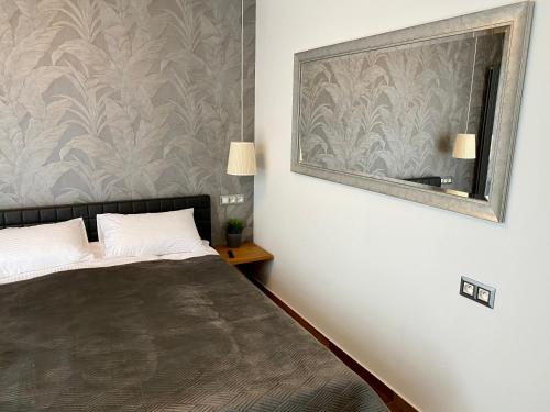 a bedroom with a bed and a mirror at Horyzont Luksusowe apartamenty nad morzem z parkingiem Międzyzdroje in Międzyzdroje