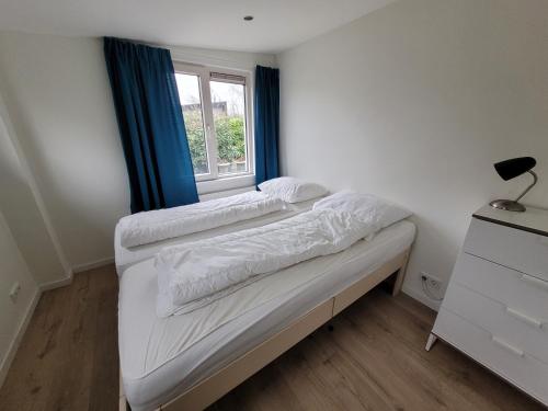 a small bedroom with a bed and a window at Zoet & Zout in Zoutelande