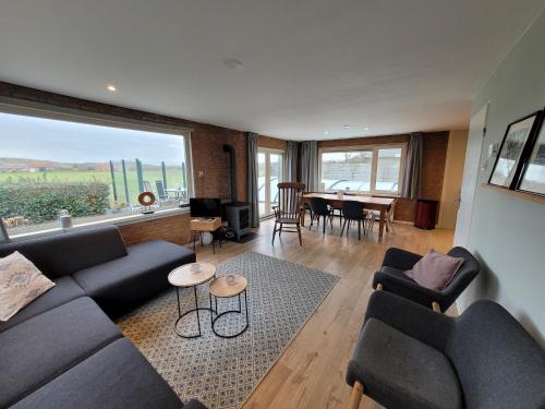 a living room with a couch and chairs and a table at Zoet & Zout in Zoutelande
