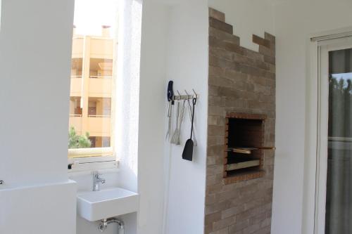a bathroom with a sink and a brick fireplace at BEACH FOREST PARADISE in Cabopino