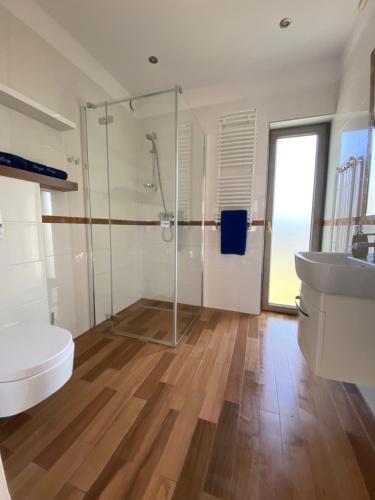 a bathroom with a shower and a toilet and a sink at Domki Poezja Ciszy in Dębki