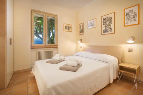 a bedroom with a white bed with towels on it at Villetta Blue Panorama With Jacuzzi in Torri del Benaco
