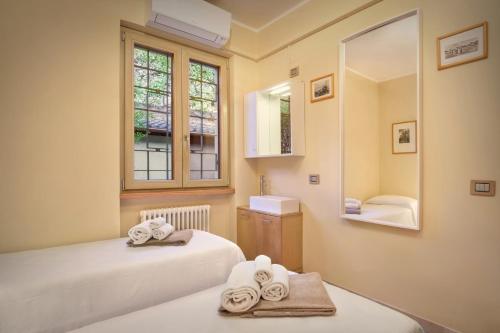 a bathroom with two beds and a mirror at Villetta Blue Panorama With Jacuzzi in Torri del Benaco