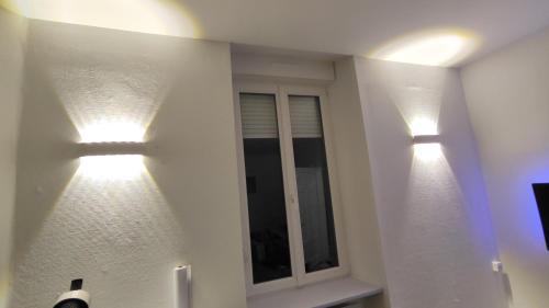 twee lichten op de muur van een badkamer bij Le Cosy Studio Logement entier [Parking Gratuit] in Algrange