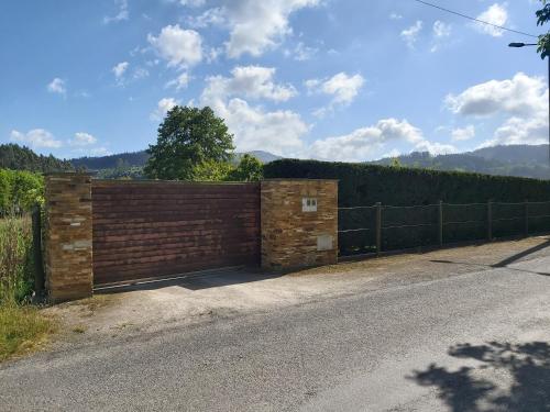 a gate in a brick wall on the side of a road at Casetón do Forno. in Lourenzá