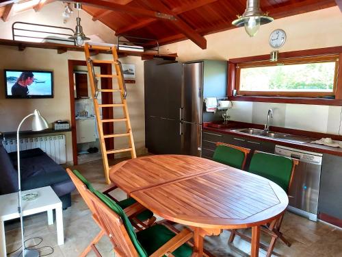 a kitchen and dining room with a wooden table and chairs at Casetón do Forno. in Lourenzá
