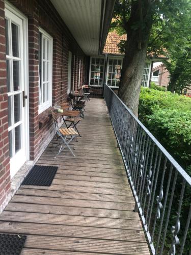 a wooden porch with chairs and a tree on a house at Hotel Farchauer Mühle in Ratzeburg