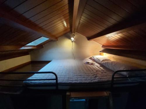 a bed in a room with a wooden ceiling at Casetón do Forno. in Lourenzá