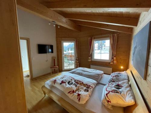 a bedroom with two beds in a wooden house at Chalet Inge in Saas-Fee