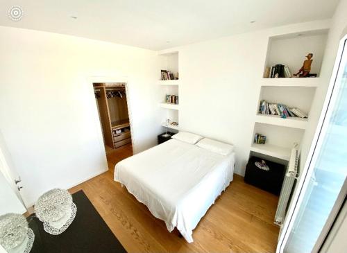 - une chambre avec un lit blanc et des étagères blanches dans l'établissement Tramontana House, à Carmiano