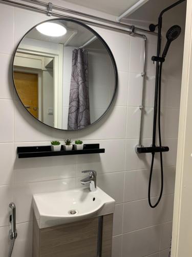 a bathroom with a sink and a mirror at StarHomes Hallituskatu 23 in Oulu