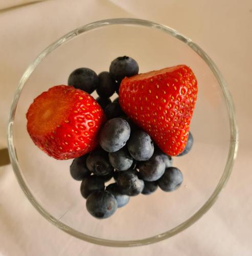 a bowl of fruit with strawberries and blueberries at Hotel Perla Del Mare in Lido di Camaiore