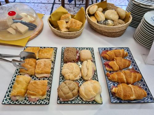 a table with plates of pastries and baskets of food at Hotel Perla Del Mare in Lido di Camaiore