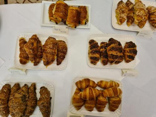 a table topped with trays of pastries and croissants at Hotel Perla Del Mare in Lido di Camaiore