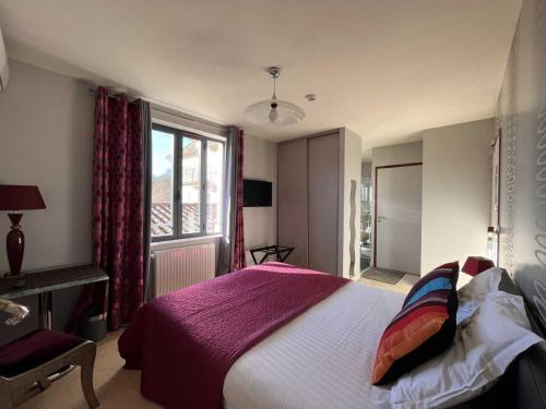 a bedroom with a large bed and a window at Le Vinois in Caillac
