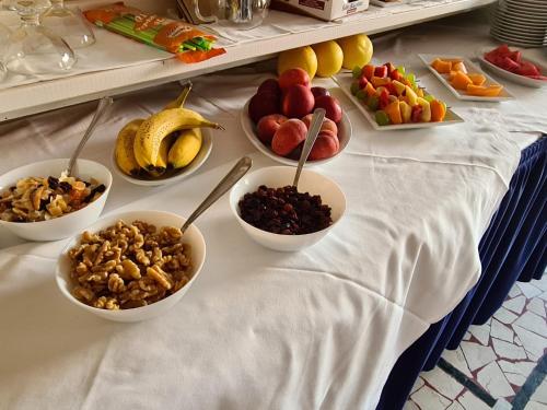 a table topped with bowls of fruits and nuts at Hotel Perla Del Mare in Lido di Camaiore