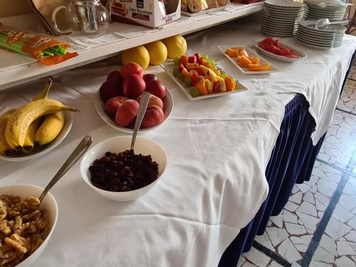 a table with bowls of fruit and bowls of nuts at Hotel Perla Del Mare in Lido di Camaiore