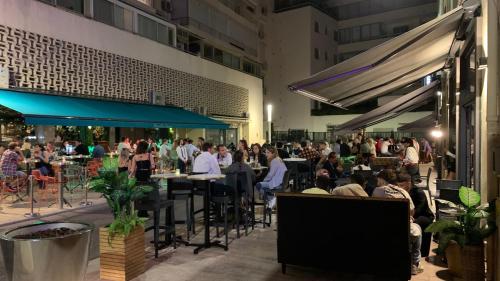 Une foule de personnes assises à table dans un restaurant dans l'établissement Village Croisette, à Cannes