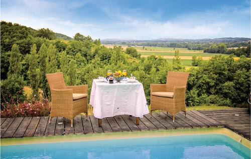 - une table et des chaises sur une terrasse à côté de la piscine dans l'établissement Awesome Home In Masseube With Sauna, à Panassac