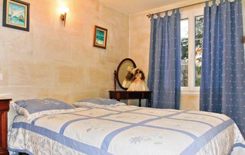 a bedroom with a bed with blue curtains and a mirror at 3 Bedroom Beautiful Home In Boulbon in Boulbon
