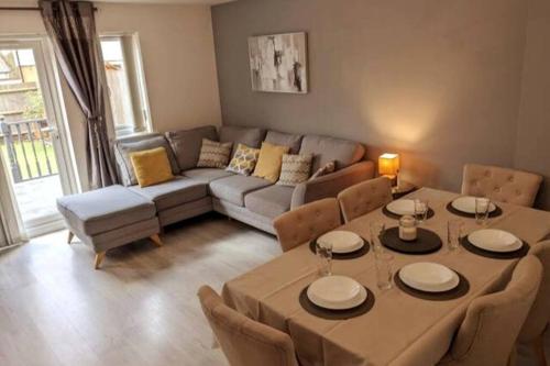 uma sala de estar com uma mesa e um sofá em Entire 3 bed home Sleeps 6, WiFi, 2 Parking Spaces em Milton Keynes