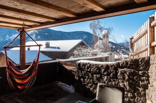 a hammock on a balcony with a view of the mountains at Oberpiskoihof in Funes