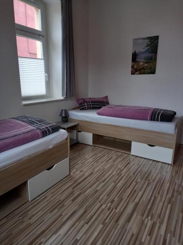 a room with two beds and a window at Südvorstadt in Zittau