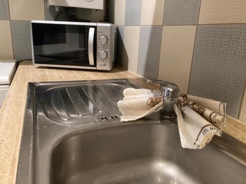 a sink in a kitchen with a microwave at Find for the traveler in Tallinn