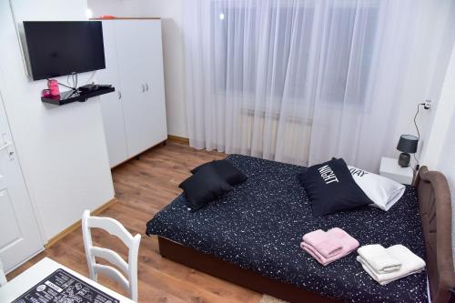 a small room with a bed and a television at Apartmani Koko in Banja Luka