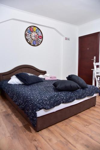 a bed in a bedroom with a clock on the wall at Apartmani Koko in Banja Luka