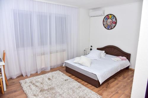 a bedroom with a bed with white sheets and a rug at Apartmani Koko in Banja Luka