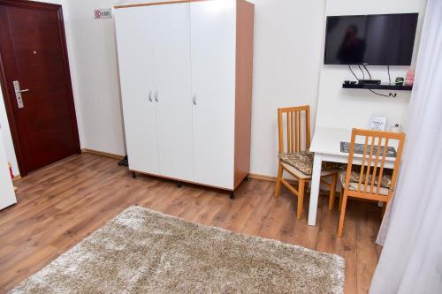 a room with a table and a white refrigerator at Apartmani Koko in Banja Luka
