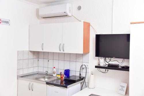 a small kitchen with a sink and a tv at Apartmani Koko in Banja Luka