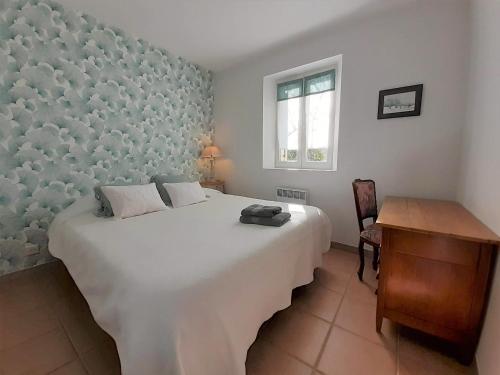 Un dormitorio con una gran cama blanca y un escritorio. en Le Mazet Du Domaine, en Gordes