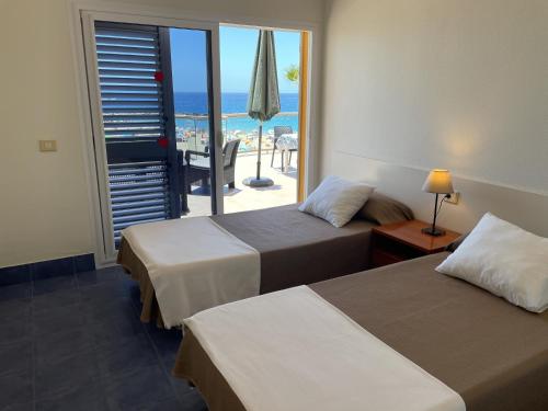 2 bedden in een hotelkamer met uitzicht op de oceaan bij RentOnTheBeach in Los Cristianos