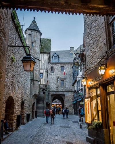 un groupe de personnes marchant dans une rue dans une allée dans l'établissement LEPETIT NID DU MONT Maison normande proche de la baie du Mont Saint Michel, à Pontorson
