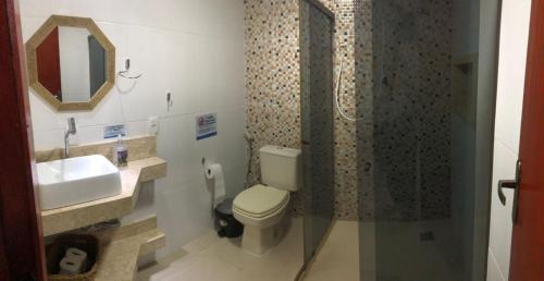 a bathroom with a toilet and a sink and a shower at Canto da Praia Suítes in Arraial do Cabo