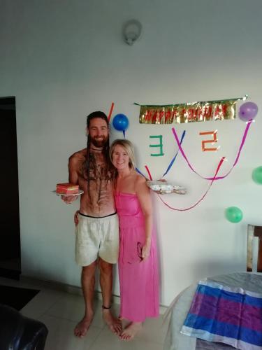a man and woman standing in front of a wall with balloons at Dreamscape home stay in Kandy