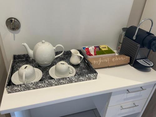 a counter with two tea sets on a tray at Menlyn Maine Trilogy Hotel in Pretoria