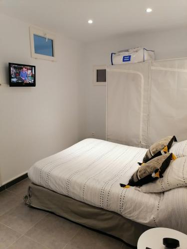 a bed in a white room with avertisement at Appartement entièrement rénové in Cerbère
