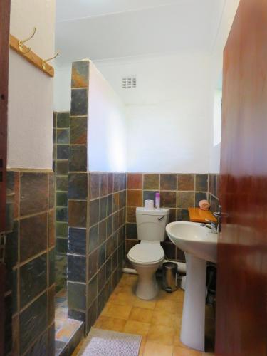 a bathroom with a toilet and a sink at Pine Valley in Lanseria