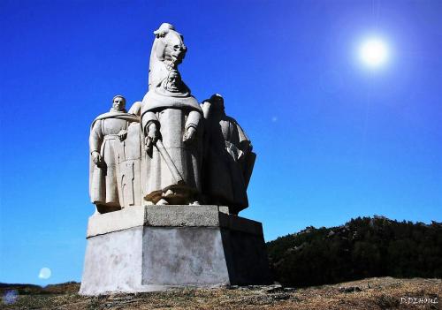 a statue on a hill with the sun in the sky at Gîte des trois vallees in Nouzonville