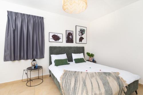 a bedroom with a large bed with green pillows at Apartment in Rehavia Jerusalem in Jerusalem
