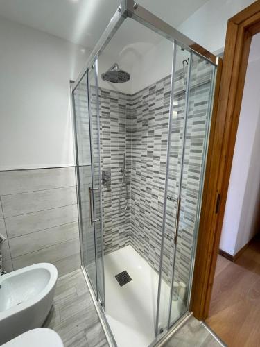 a glass shower in a bathroom with a toilet at Appartamento Ca' Baci' in Pigna