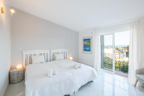 ein weißes Schlafzimmer mit einem großen weißen Bett und einem Fenster in der Unterkunft Beach Praia - Sleep 5 - Pool - Free wi-fi - Air Con in Albufeira